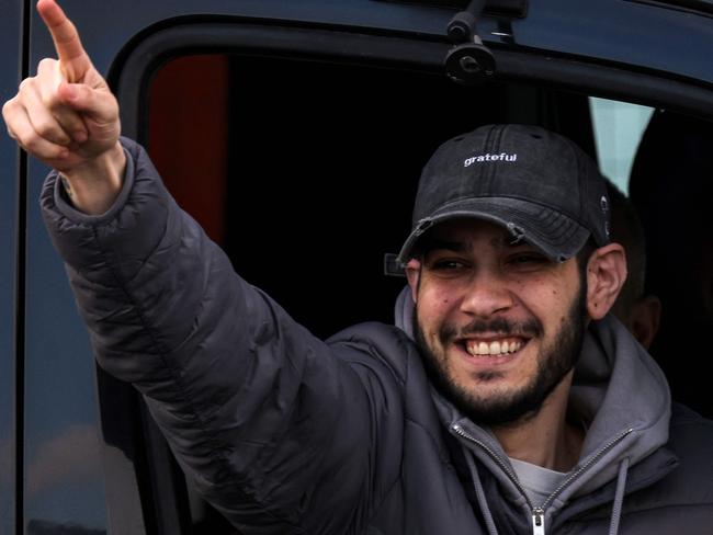 TOPSHOT - Newly-released Israeli hostage Eliya Cohen gestures as he arrives in a vehicle at Beilinson Hospital in the Rabin Medical Centre in Petah Tikva in central Israel on February 22, 2025. Three more Israeli hostages were freed by Hamas militants at a ceremony in central Gaza on February 22 after two others were released in the southern part of the Palestinian territory. (Photo by AHMAD GHARABLI / AFP)