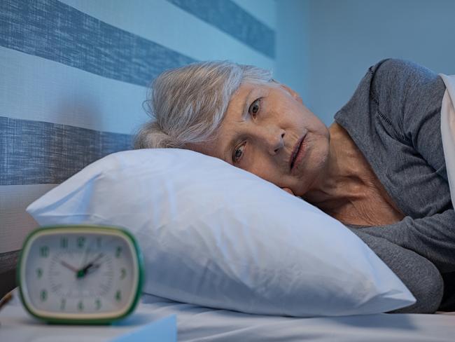 Worried senior woman in bed at night suffering from insomnia. Old woman lying in bed with open eyes. Mature woman unable to sleep at home; retirement money generic