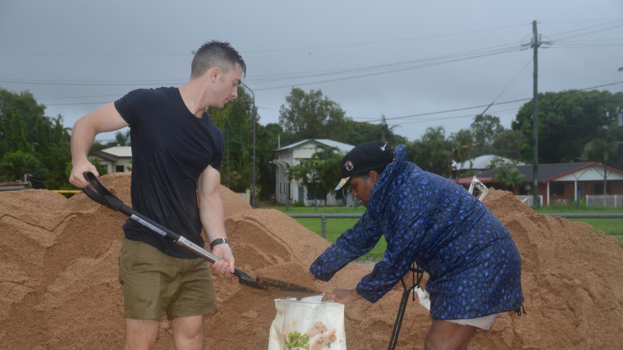 Marion Callope, who lives on Windsor St in Hermit Park, filling sandbags with help from an ADF member. Photo: Chris Lees