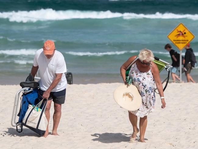 Beachgoers leave the sand after the closure of Bondi Beach. Picture: James Gourley