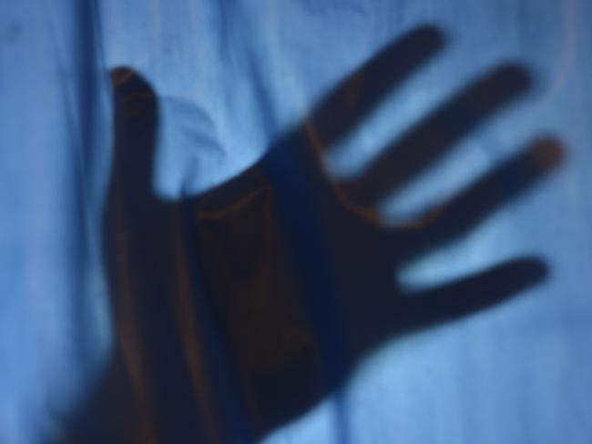 Help concept with hand silhouette behind a curtain.Victim reaching for help behind a curtain.