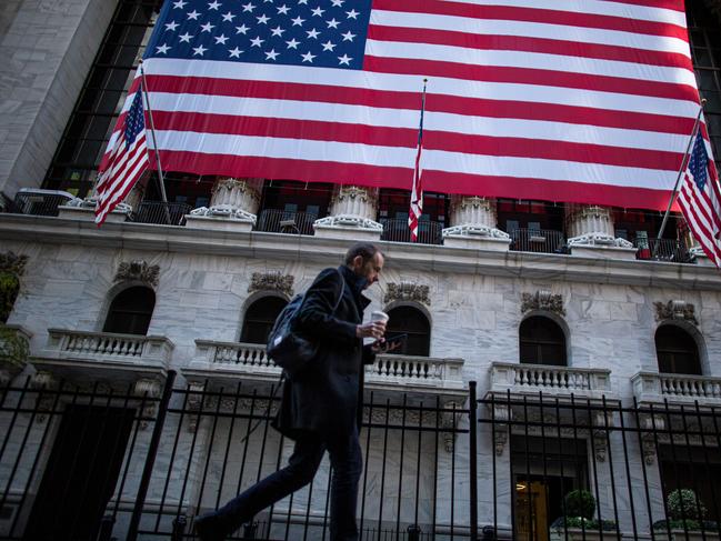 A man walks by the New York Stock Exchange (NYSE) on November 4, 2020 in New York. - Wall Street stocks were in rally mode Wednesday, shrugging off uncertainty over the still-unresolved presidential election and the likelihood of divided government in Washington.The Dow Jones Industrial Average was up 2.0 percent, or about 560 points, at 28,041.28 at around 1530 GMT, (Photo by Kena Betancur / AFP)