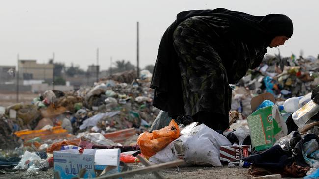 An Iraqi woman collects recoverable items from a dump in al-Fadiliya, east of Baghdad. Poorer countries need efficient development projects that save and transform lives, not feel-good, inefficient climate programs. Picture: Ahmad Al-Rubaye/AFP