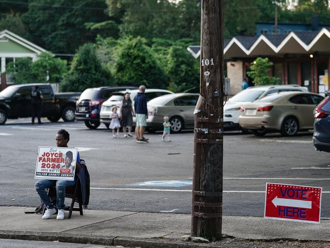 ATLANTA, GEORGIA - MAY 21: A woman holds a campaign sign outside a polling location on May 21, 2024 in Atlanta, Georgia. Among the races on the ballot in Fulton County is Scott McAfee, the Fulton County Superior Court Judge overseeing former president Donald Trump's election interference criminal trial.   Elijah Nouvelage/Getty Images/AFP (Photo by Elijah Nouvelage / GETTY IMAGES NORTH AMERICA / Getty Images via AFP)