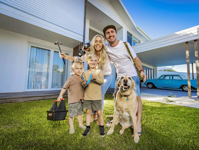 REAL ESTATE EGN case study: Kimberley and Kyle Bate (correct) with their two sons, Lennox, 5, and Spencer, 2, at their Mermaid Waters home. They have renovated fixer-uppers to sell in order to live mortgage-free without stress of rising cost of living They have also been able to restore their 1964 EH Holden 'blueberry'.* Dog is 10-year-old Winston.Picture: NIGEL HALLETT