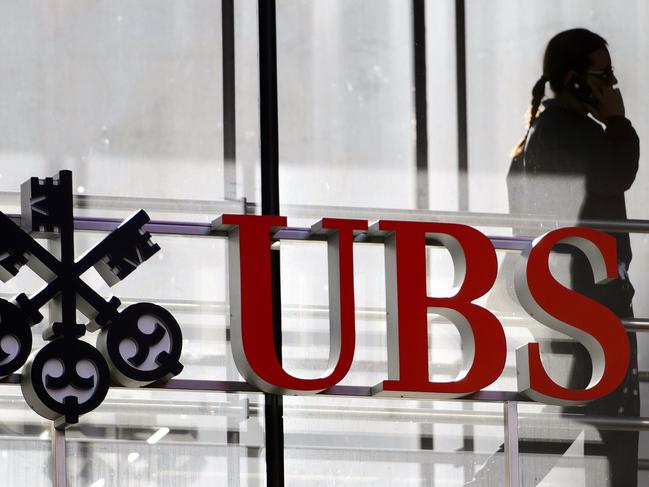 (FILES) In this file photo taken on October 30, 2012 an employee walks past a logo of the Swiss banking giant UBS in Zurich. - The national financial prosecutor condamnes UBS on November 8, 2018 to a fine of 3.7 billion euros for illegally and conscientiously approaching wealthy French customers, and hiding billions of undeclared assets. The trial of UBS at the Criminal Court of Paris for orchestrating a large tax fraud system continues until November 15, 2018. (Photo by Fabrice COFFRINI / AFP)