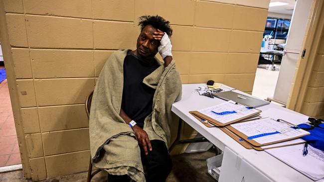 An injured man sits inside a makeshift clinic and relief centre in Rolling Fork. Picture: Chandan Khanna / AFP