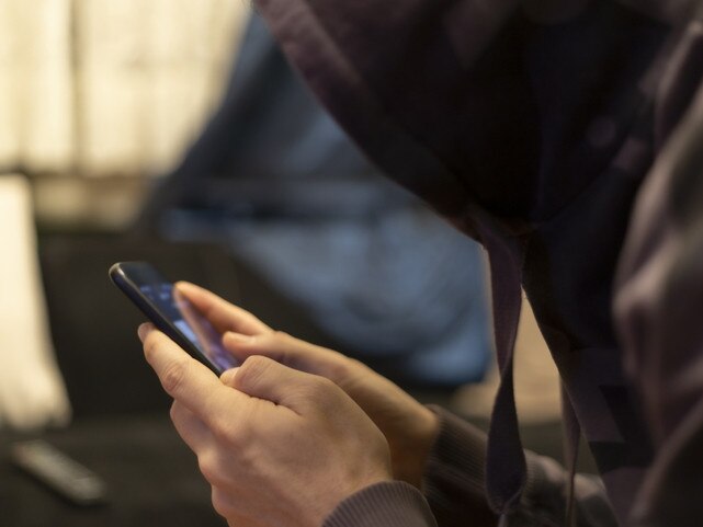 Mysterious man with hoodie, using his smartphone for unknown reasons Photo: iStock