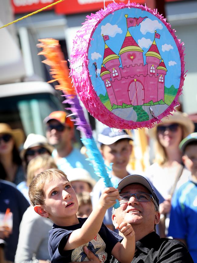 Luca Caporelli, 5, of Sandy Bay, gives a pinata a whack with some help from Dino Ottavi.