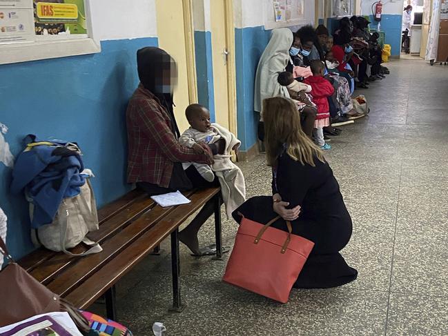 A young mother sitting in a community clinic in a shanty town in Nairobi asks MP Tania Lawrence (R) to take her baby away for a better life. Picture: Ellen Whinnett / The Australian