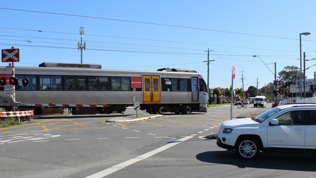 A train passes through the notorious Lindum rail crossing. Picture: Damian Bathersby