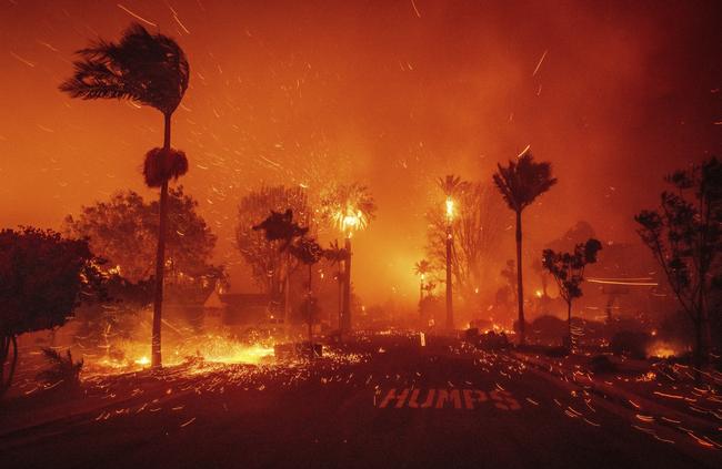 The Palisades Fire ravages a neighborhood amid high winds in the Pacific Palisades neighborhood of Los Angeles, Tuesday, Jan. 7, 2025. (AP Photo/Ethan Swope)