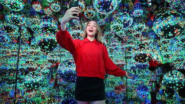 Art lover Anna Lynn takes a moment to reflect in a Yayoi Kusama infinity mirror room at the NGV. Picture: David Caird