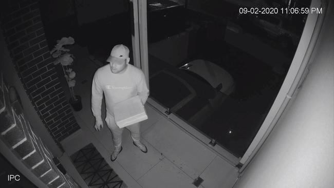 A man pretending to deliver a pizza waits for Geokjian to answer door. Picture: NSW Police