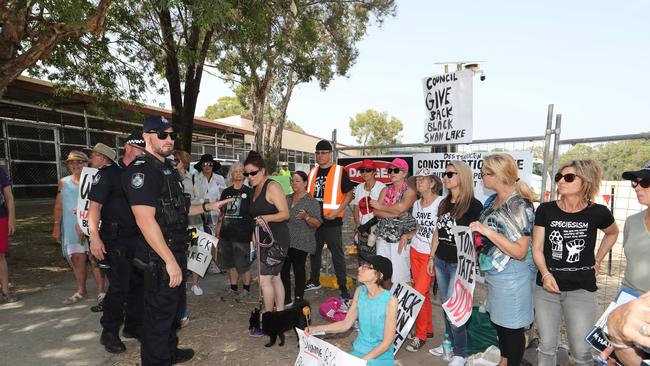 Black Swan Lake protest at Bundall goes to another level, with protesters chaining themselves to the fence and then getting themselves arrested after running onto the worksite and stopping the trucks. Police inform protesters of the situation. Picture Glenn Hampson