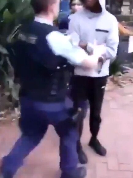 The officer is seen placing the boy’s hands behind his back. Source: Monica Kelly