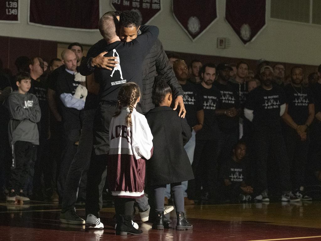 Kobe Bryant's cousin John Cox is hugged by Lower Merion Coach Gregg Downer.