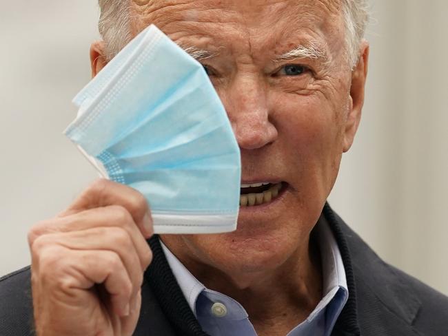 Democratic presidential candidate Joe Biden holds up his facemask as he speaks at a voter activation center in Chester, Pennsylvania, on October 26, 2020. - President Donald Trump on Monday barnstormed Pennsylvania -- a swing state he almost certainly has to win to get reelected -- while his Democratic opponent Joe Biden once more kept a low profile. (Photo by JIM WATSON / AFP)