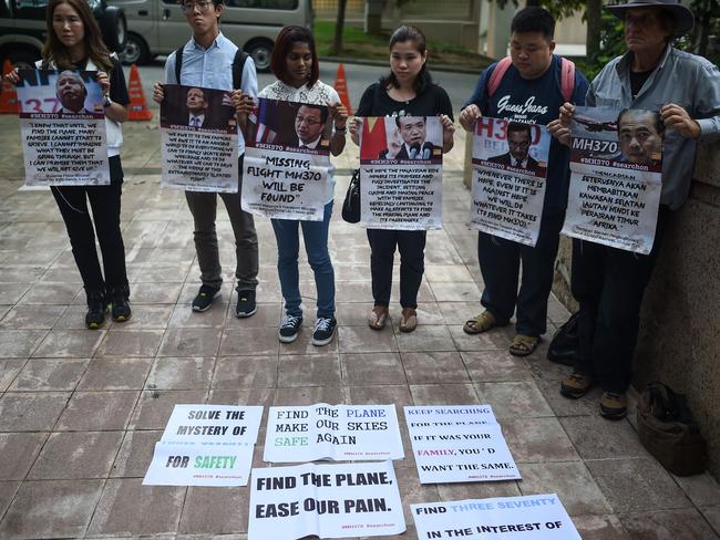 Relatives of passengers who were on board Malaysia Airlines MH370 hold placards outside the Malaysian federal administrative centre in Putrajaya, near Kuala Lumpur. Picture: AFP/Mohd Rasfan