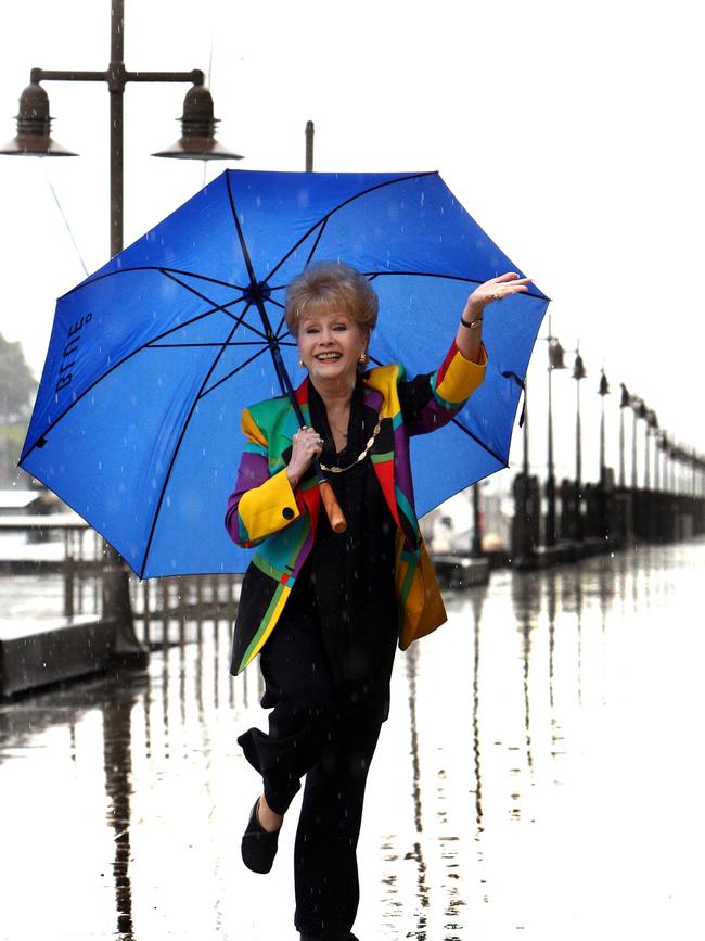 Actor and singer Debbie Reynolds, who starred in 1951 film Singin in the Rain, at Woolloomooloo, enjoys a downpour in Sydney as she prepares for her Australian Concert Tour.
