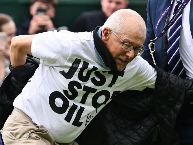 A Just Stop Oil demonstrator is escorted out of court 18 after disrupting the women's singles tennis match between Australia's Daria Saville and Britain's Katie Boulter on the third day of the 2023 Wimbledon Championships at The All England Tennis Club in Wimbledon, southwest London, on July 5, 2023. (Photo by Glyn KIRK / AFP) / RESTRICTED TO EDITORIAL USE