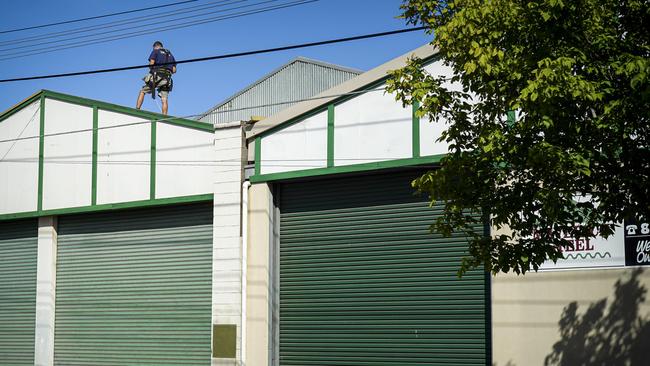 A man could be seen working on the roof of the steel workshop the day after Mr Wright died. Picture: AAP/Mike Burton