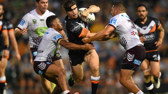 Chris Lawrence of the Tigers is tackled by Apisai Koroisau, (left) and Lewis Brown.