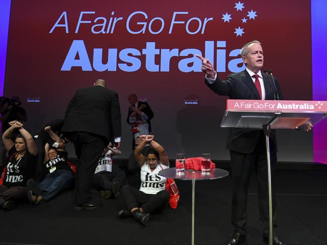 ‘Anti-Adani’ protesters are removed from stage as Australian Opposition leader Bill Shorten speaks during day one of the Labor Party National Conference on Sunday. Picture: AAP