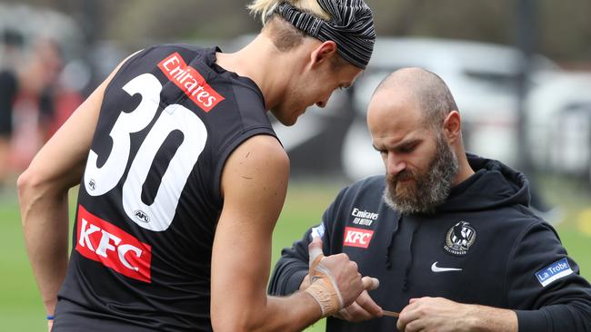 Darcy Moore gets his hand and wrist strapped at training. Picture: David Crosling