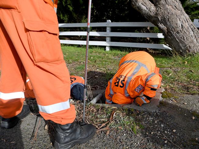 An SES volunteer searches a drain. AAP Image/Joe Castro