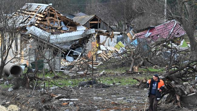 A road service worker stands in front of destroyed houses in the village Zalissya, northeast of Kyiv on April 12.