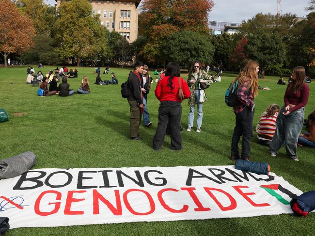 Students gather with signs on the lawn at University of Melbourne. Picture: Jason Edwards