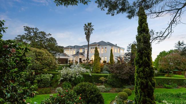 Manicured gardens provide a verdant backdrop to the home’s elegant architecture.