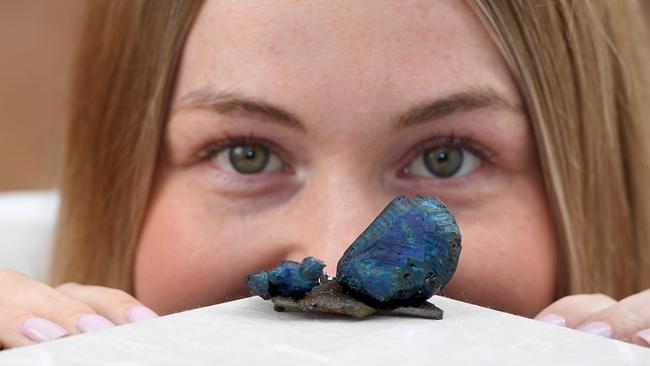 Ash Sambrooks with the worlds best bornite specimen at the SA Museum which is South Australia's mineral emblem. Picture: Naomi Jellicoe