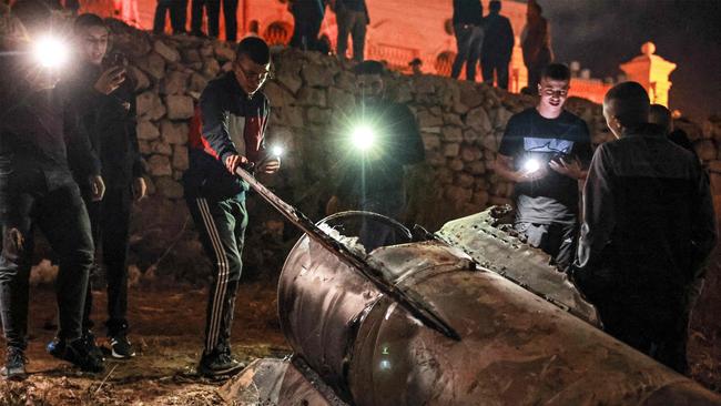 Palestinian youths inspect a fallen projectile after Iran launched a barrage of missiles at Israel. Picture: AFP