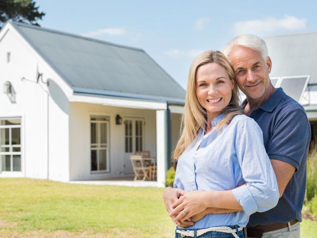 Sunday Mail, Looking Forward - Cheerful senior couple standing outside their new house. Happy mature couple looking at camera outdoor. Senior man embracing woman from behind in garden of house.