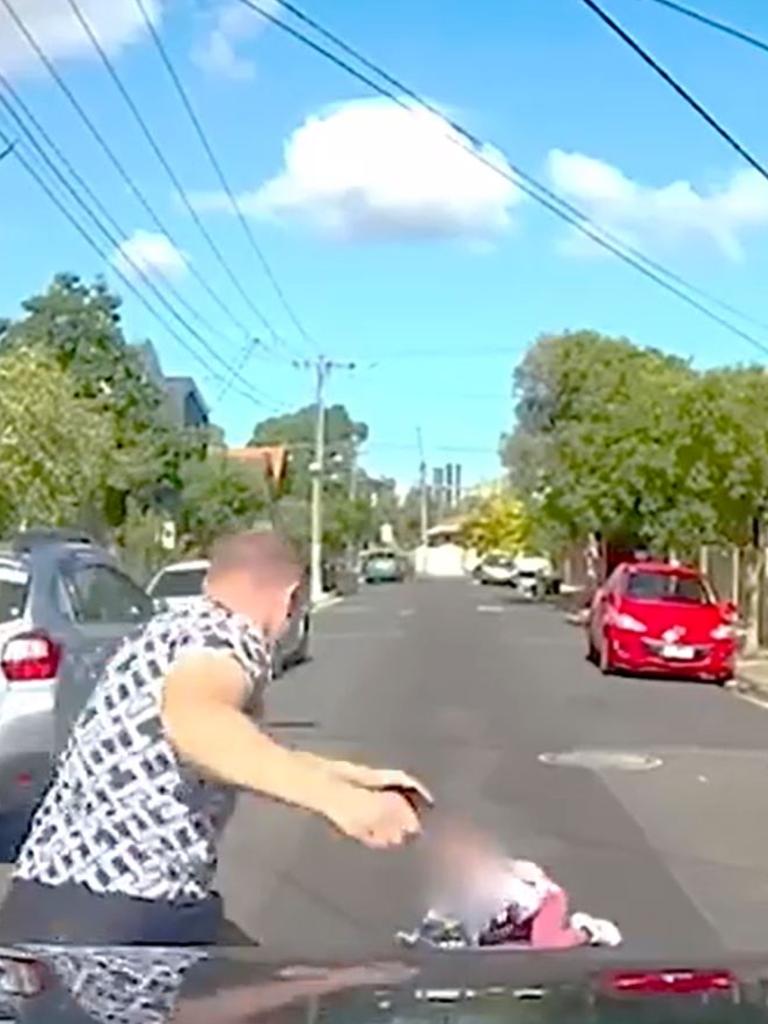 The man smashed his fist into the bonnet before running to the girl. Picture: DashCamOwnersAustralia / Facebook
