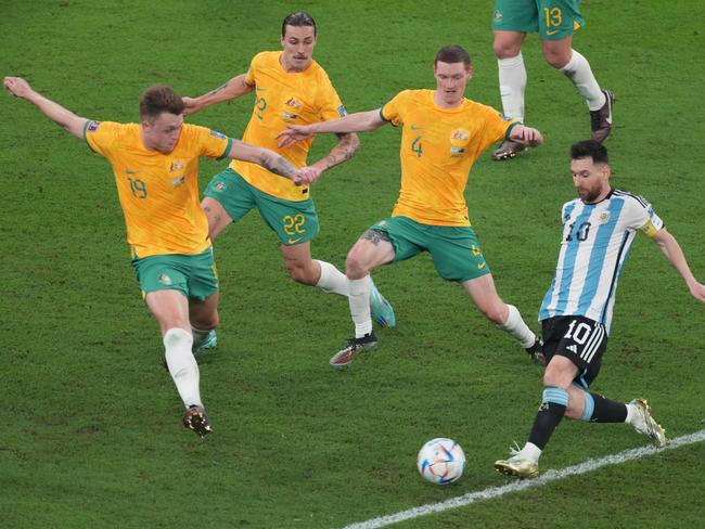 DOHA, QATAR - DECEMBER 03: Lionel Messi of Argentina in action under pressure from Harry Souttar, Jackson Irvine and Kye Rowles of Australia during the FIFA World Cup Qatar 2022 Round of 16 match between Argentina and Australia at Ahmad Bin Ali Stadium on December 03, 2022 in Doha, Qatar. (Photo by Etsuo Hara/Getty Images)