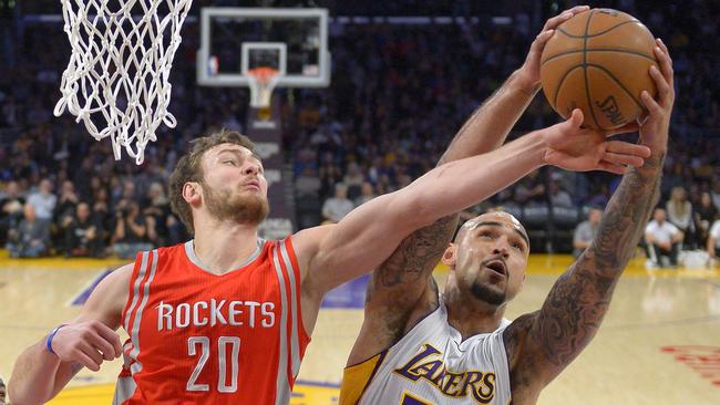 LA’s Robert Sacre, right, grabs a rebound away from Houston Rockets forward Donatas Motiejunas.