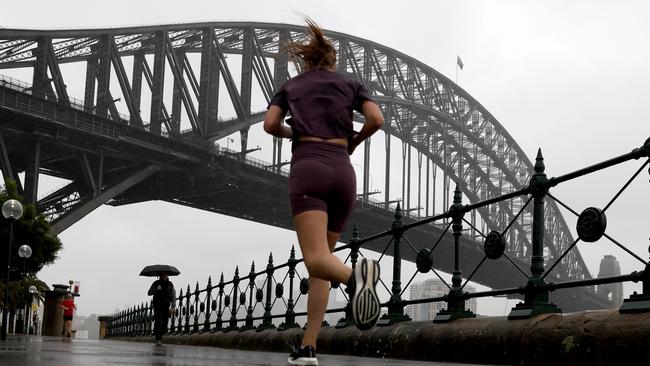 People out on a wet and rainy morning in Sydney near the Sydney Harbour Bridge. Picture: NewsWire / Damian Shaw