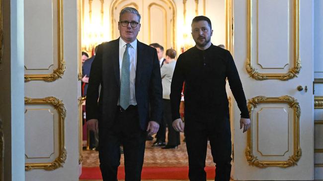Britain's Prime Minister Keir Starmer (L) and Ukraine's President Volodymyr Zelensky (R) head to a private room during the summit at Lancaster House. Picture: AFP.