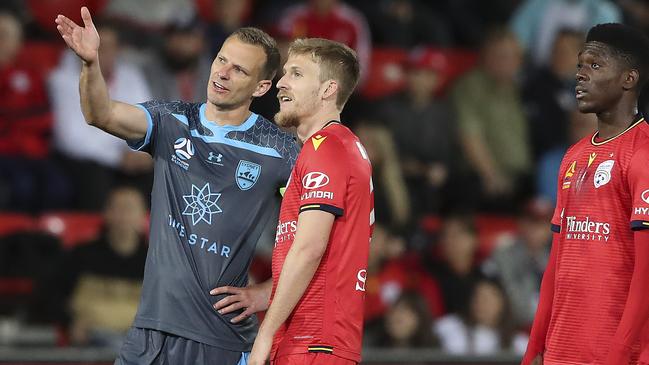 Sydney FC’s Alex Wilkinson and (left) and Adelaide United’s Ben Halloran wait for the results of a VAR review. Picture: Sarah Reed