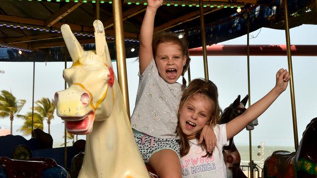 Laila, 5, and Skye Healing, 6, from Idalia go for a ride on the carousel at the Stable on the Strand. Picture: Evan Morgan