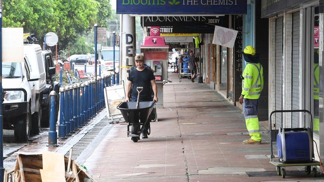 Workers continued to clear damaged businesses in the main town on March 28, before the second deluge hit. Picture: Getty Images