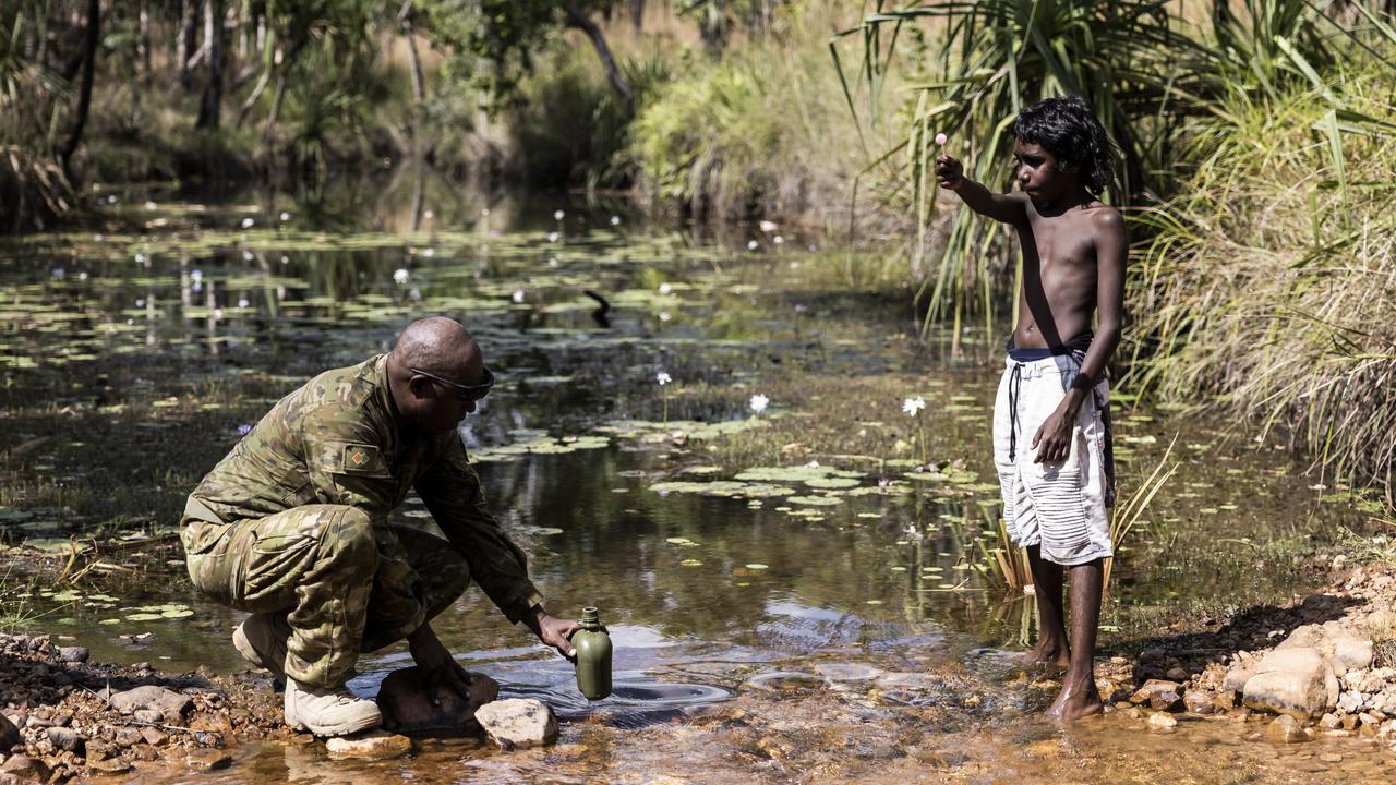 Private Misman Kris collects water next to local boy Lincoln Raymond. Picture: Dylan Robinson