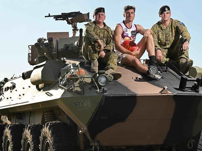 19/4/2024: Brisbane Lions defender Noah Answerth with (L-R) Trooper Bryce Newton and LT Hamish Boxall, on an Army ASLAV and troops at the Brighton Homes Arena, Springfield. pic: Lyndon Mechielsen/Courier Mail