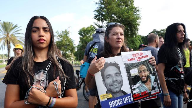 Symbolically chained demonstrators carry pictures of hostages in front of the Israeli defence ministry in Tel Aviv on Friday during a protest calling for action to secure the release of Israelis held captive since the October 7 attacks by Palestinian fighters. Picture: Jack Guez/AFP