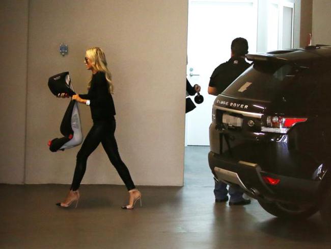 Back home in North Bondi, Roxy Jacenko removes a child’s seat from the Range Rover which brought the family from Sydney Airport.