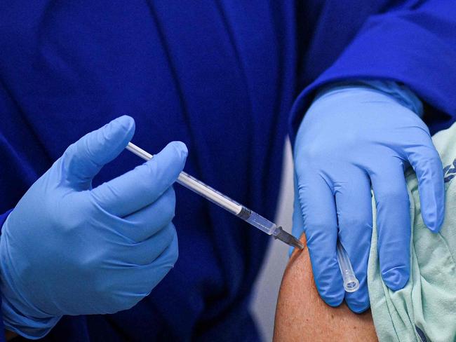 A health worker receives a dose of the Pfizer-BioNTech vaccine against COVID-19 at the Versalles Clinic, in Cali, Colombia, amid the novel coronavirus pandemic on February 19, 2021. (Photo by Luis ROBAYO / AFP)