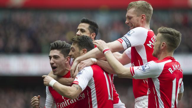 Arsenal's Mesut Özil, second from left, celebrates with team mates, from left, Hector Bellerin, Alexis Sanchez, Per Mertesacker and Aaron Ramsey after scoring against Liverpool, during their English Premier League soccer match, at Emirates Stadium, in London, Saturday, April 4, 2015. (AP Photo/Bogdan Maran)